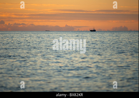 Eine schöne schimmernde Seenlandschaft Blick auf ein einsames Fischerboot bei Sonnenuntergang erschossen von der Ardnamurchan-Halbinsel Stockfoto