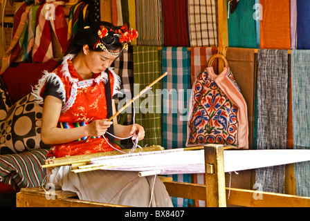 Junge Frau, die Weberei im Textilgeschäft, Lijiang, Yunnan, China Stockfoto