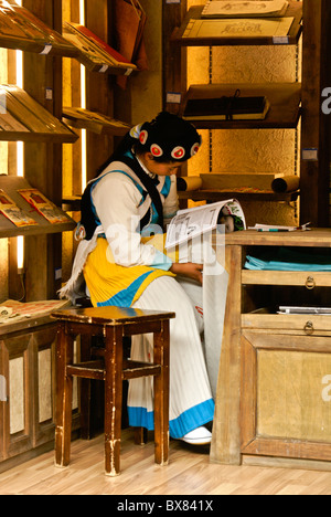 Naxi Mädchen lesen im Art Shop, Lijiang, Yunnan, China Stockfoto