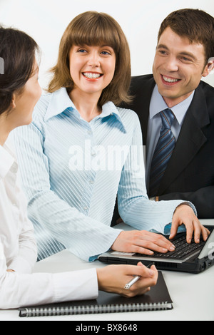 Team von drei jungen Geschäftsleute versammelt um den Laptop diskutieren interessante Frage Stockfoto