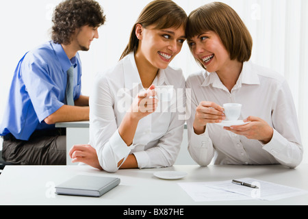 Porträt von zwei Business-Frauen halten Tassen Kaffee in der Hand am Tisch Stockfoto