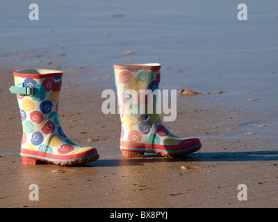 Ein paar Gummistiefel für Kinder am Strand, Cornwall, UK Stockfoto