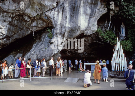 Lourdes, Frankreich: Pilger besuchen die Statue der Muttergottes von Lourdes in der Grotte von Massabielle, Lourdes, Frankreich. Stockfoto