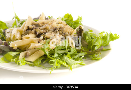 Penne einfügen in cremiger Pilz, Knoblauch und Zwiebel Sauce auf Bett aus Salatblättern, isoliert auf weiss Stockfoto