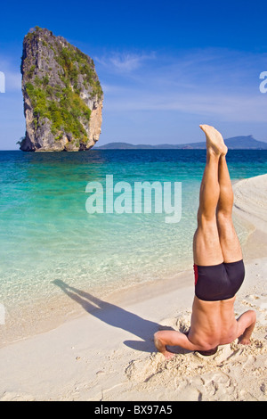 Männliche Handstand am Strand Stockfoto