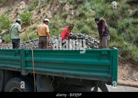 Männer auf der Ladefläche eines Lastwagens in Datong, Shanxi, China zusammen arbeiten. Stockfoto