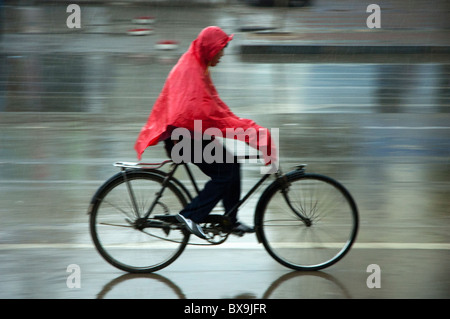 Mann auf seinem Fahrrad unter einem Sturm, Datong, Shanxi, China zu beschleunigen. Stockfoto