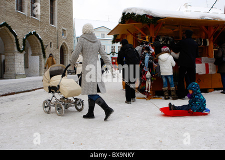 Mutter ihr Kind mit dem Hammer am Raekoja plats(square) ziehen. Weihnachten in Tallin, Estland Stockfoto