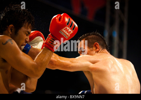 Linken jab von kaukasischen Muay thai Kämpfer Landung auf Gesicht der asiatischen Kickboxen Gegner bei Amateur Outdoor-Kampf Stockfoto