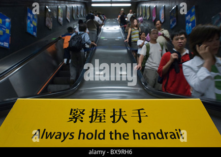 Fahrgäste fahren die Rolltreppe in einem u-Bahn Tunnel, Hong Kong Island, Hongkong, China. Stockfoto