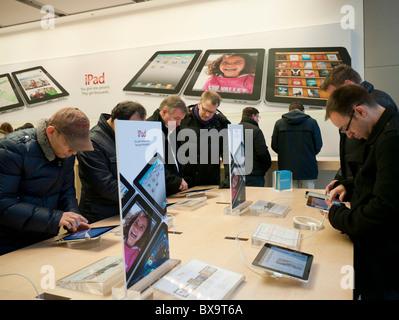 Menschen betrachten das Apple iPad im Apple Store in der Regent Street London Großbritannien ausgestellt Stockfoto