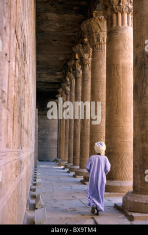 Tempel von Edfu, Edfu, Ägypten - gekleidete Mann in traditioneller Kleidung zu Fuß zwischen Spalten Stockfoto