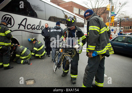 First Responder-Teams das beschädigte Fahrrad von einem Radfahrer zu entfernen, nachdem er von einem Bus drehen in New York getroffen wurde Stockfoto