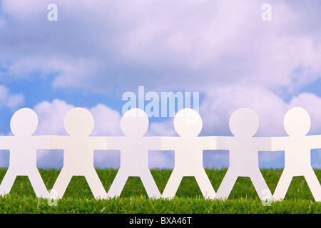 Konzept-Bild von Papier Männer Hand in Hand in einem Feld mit Himmelshintergrund Stockfoto