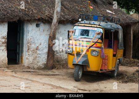 Indische Rikscha vor einem ländlichen Dorfhaus. Andhra Pradesh, Indien Stockfoto