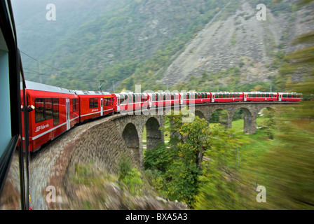 Landschaft in Bewegung verwischen Panorama Triebwagen der Rhätischen Bahn Bernina Express Zug auf kreisförmigen Viadukt bei Brusio Italien Stockfoto