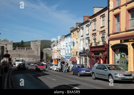 Ein Blick auf eine Parade von bunten Geschäfte auf der Castle Street in Cahir in Richtung Cahir Castle, Co. Tipperary, Irland (Eire). Stockfoto