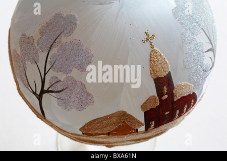 Nahaufnahme von Glitter hängenden Ball mit schneereichen Winter Kirche Szene auf weißem Hintergrund Stockfoto