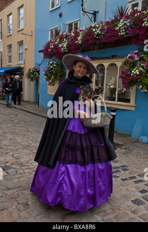 Frau, gekleidet in historischen Kostümen mit Blumenkorb außerhalb Schloss Windsor, Windsor, Berkshire, England Stockfoto