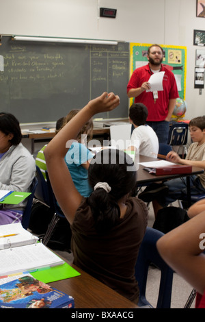 Sechsten Klasse Mädchen hebt die Hand als Reaktion auf männliche Lehrer Frage in Sozialkunde Klasse Mittelschule Unterricht in Austin Stockfoto