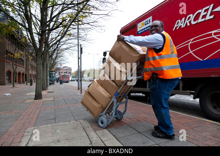 Ein Kurier verwendet einen Trolley, um schwere Pakete zu bewegen. Stockfoto