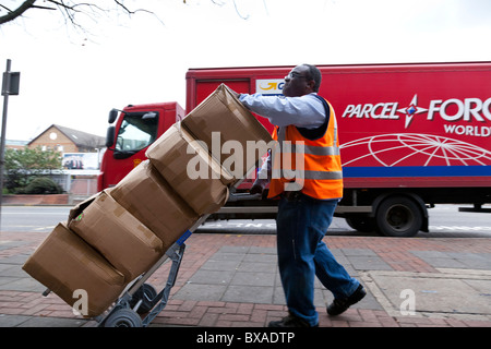 Ein Kurier verwendet einen Trolley, um schwere Pakete zu bewegen. Stockfoto