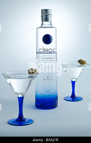 Eine Flasche CIROC Vodka auf weißem Hintergrund mit garniert passenden Cocktailgläser im Vordergrund. Stockfoto