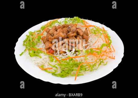 Chinesisches Essen. Gebratenes Schweinefleisch mit Stärke Nudeln, geriebenen Karotten und Salat. Stockfoto