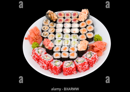 viele Sushi Rollen auf einem großen Teller, isoliert auf schwarz, Schneidepfad Stockfoto