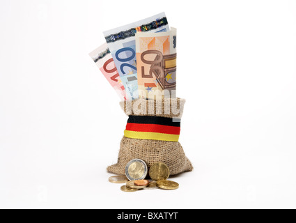 Münzen vor der etwas grobe Jute-Tasche mit Euro-Banknoten Stockfoto