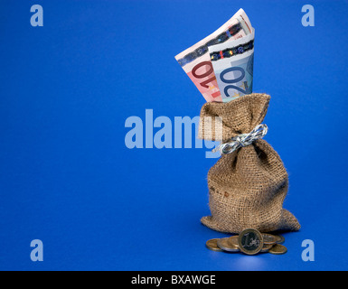 Münzen vor der etwas grobe Jute-Tasche mit Euro-Banknoten Stockfoto