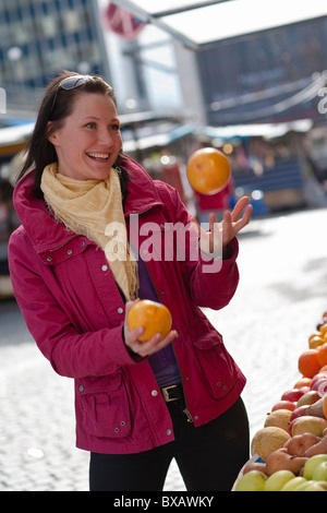 Junge Frau mit frischen Orangen jonglieren Stockfoto