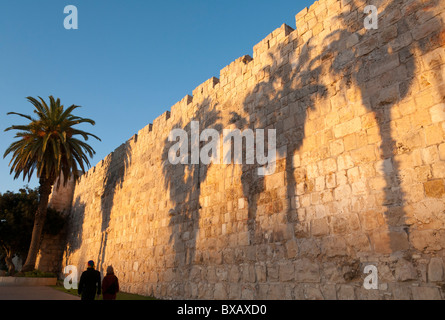 Sonnenuntergang an der alten Stadtmauer-Promenade in der Nähe von Jaffa-Tor mit Palm Bäume Schatten und paar vorbeikamen. Jerusalem. Israel Stockfoto