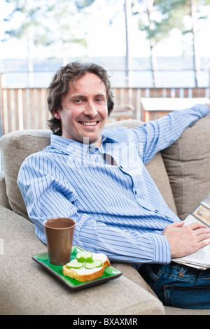 Portrait von fröhlichen mittleren Erwachsenenalter Mann auf sofa Stockfoto