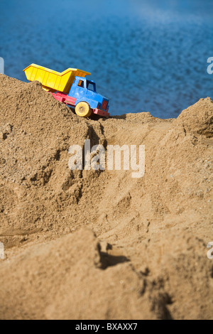 Spielzeug-LKW auf Sandhaufen Stockfoto