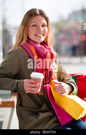 Porträt der jungen Frau mit Kaffeetasse und Einkaufstasche Stockfoto