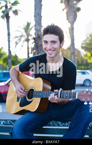 Porträt des jungen Mannes, Gitarre spielen, im freien Stockfoto