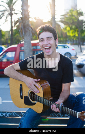 Porträt des jungen Mannes, Gitarre spielen, im freien Stockfoto