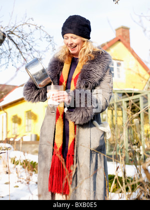 Frau trinken heißen Schokolade, Lächeln Stockfoto
