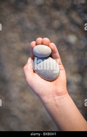 Kind hält Kiesel Stockfoto