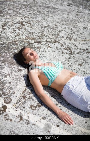 Frau liegend auf Felsen Stockfoto