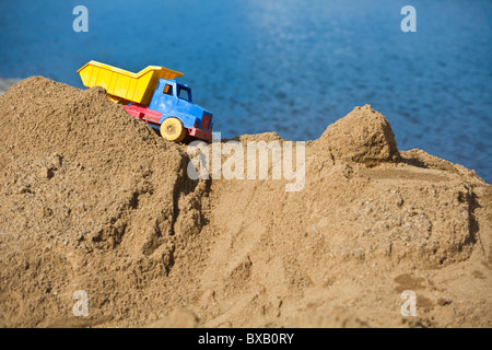 Spielzeug-LKW auf Sandhaufen Stockfoto