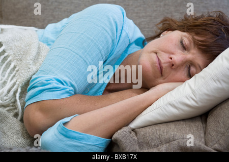 Reife Frau auf Bett liegend Stockfoto