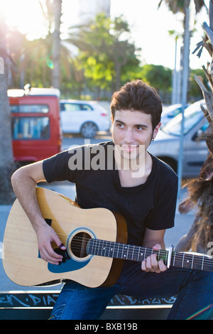 Porträt des jungen Mannes, Gitarre spielen, im freien Stockfoto