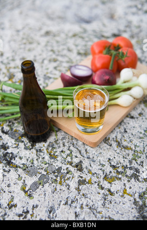 Gemüse und Bier auf Schneidebrett Stockfoto