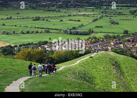 Eine Gruppe von Wanderern auf dem Weg vom Gipfel des Glastonbury Tor mit Blick auf den Somerset Levels, England, UK Stockfoto