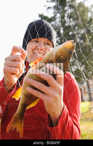 Frau Fisch vom Fischernetz herausnehmen Stockfoto