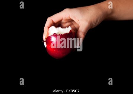 Frau mit roter Apfel auf schwarzem Hintergrund Stockfoto