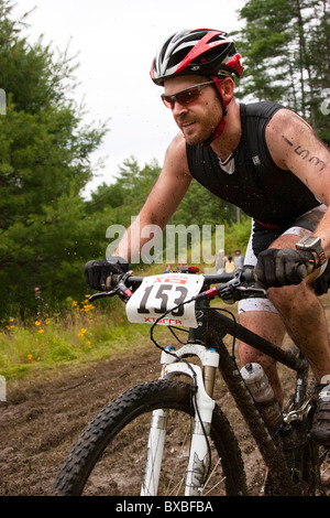 Mountainbiker Fahrten über einen schlammigen Pfad während einer off-Road-Triathlon-Wettkampf Stockfoto