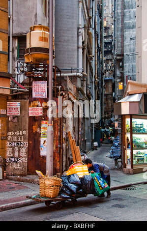 Ältere Chinesin, Schieben Karren auf Straße in Hongkong China Stockfoto